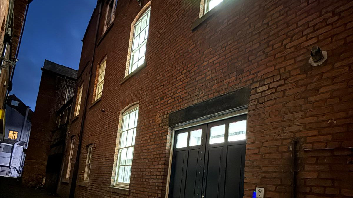 Dark alleyway with a brick building and a door