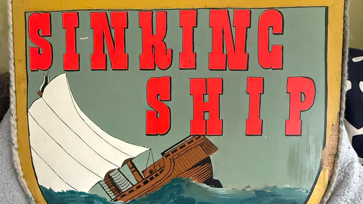 Decorative sign with 'Sinking Ship' text and illustration on a yellow border.
